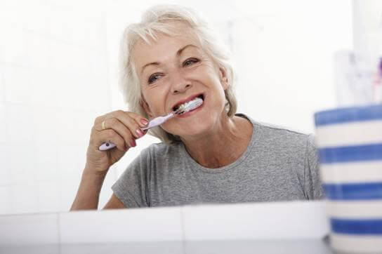 Middle-aged woman brushing her teeth